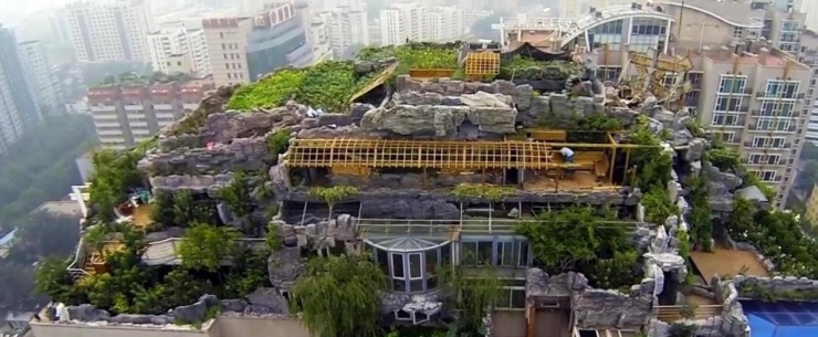 位于北京海淀区的人济山庄楼顶 大家可以看到一座假山环绕的"空中别墅